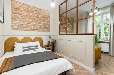 a bedroom with a brick wall and a bed at HOUSEHOST Apartment : Topolowa 26/17 in Kraków