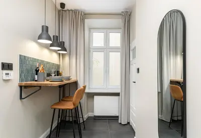a small kitchen with a table and chairs and a window at HOUSEHOST Apartment : Topolowa 26/17 in Kraków