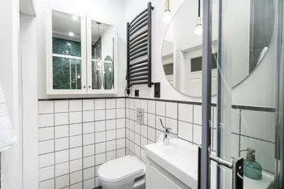 a bathroom with a toilet and a sink and a mirror at HOUSEHOST Apartment : Topolowa 26/17 in Kraków