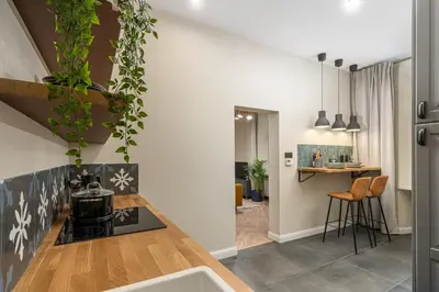 a kitchen with a counter with a stove top oven at HOUSEHOST Apartment : Topolowa 26/17 in Kraków