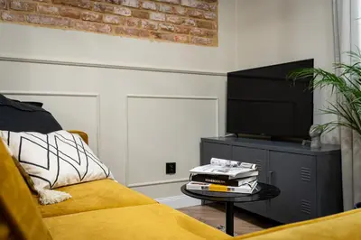a living room with a couch and a flat screen tv at HOUSEHOST Apartment : Topolowa 26/17 in Kraków