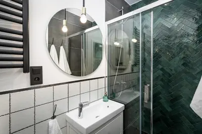 a bathroom with a sink and a mirror at HOUSEHOST Apartment : Topolowa 26/17 in Kraków