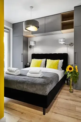 a bedroom with a large bed with yellow pillows at HOUSEHOST Apartment :Miodowa 42/4a in Kraków