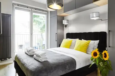 a bedroom with a large bed with yellow pillows at HOUSEHOST Apartment :Miodowa 42/4a in Kraków