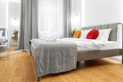 a bedroom with a bed with red and white pillows at HOUSEHOST Apartment: Św.Gertrudy 10/2.11 in Kraków