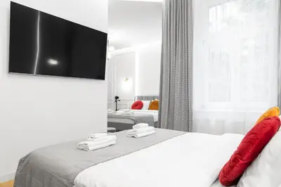 a bedroom with a bed with a flat screen tv on the wall at HOUSEHOST Apartment: Św.Gertrudy 10/2.11 in Kraków