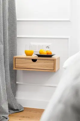 a shelf with a bowl of oranges and a glass of orange juice at HOUSEHOST Apartment: Św.Gertrudy 10/2.11 in Kraków
