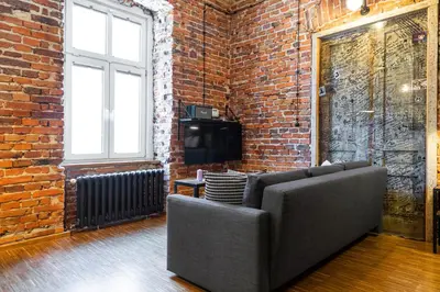 a living room with a couch and a brick wall at HOUSEHOST ApartmenI: Podbrzezie 2/20 in Kraków