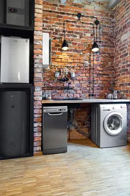 a brick kitchen with a washing machine and a washer at HOUSEHOST ApartmenI: Podbrzezie 2/20 in Kraków