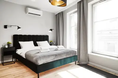 a bedroom with a large bed with a black headboard at HOUSEHOST Apartament :Miodowa 42/4b in Kraków