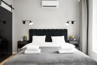 a bedroom with a large bed with a black headboard at HOUSEHOST Apartament :Miodowa 42/4b in Kraków