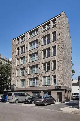 a large brick building with cars parked in a parking lot at HOUSEHOST Apartament :Miodowa 42/4b in Kraków