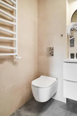 a bathroom with a white toilet and a staircase at HOUSEHOST Apartament :Miodowa 42/4b in Kraków