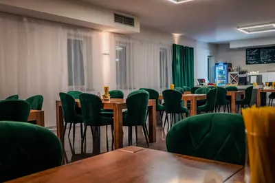 a conference room with tables and green chairs at Hotel Świt in Kraków