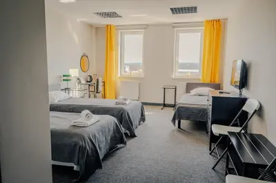 a hospital room with two beds and a television at Hotel Świt in Kraków