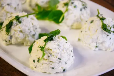 a plate of potato balls with greens on top at Hotel Świt in Kraków