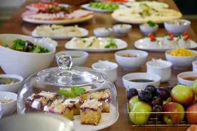 a table with plates of food and bowls of fruit at Hotel Świt in Kraków