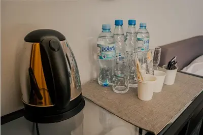 a coffee maker on a counter with bottles of water at Hotel Świt in Kraków