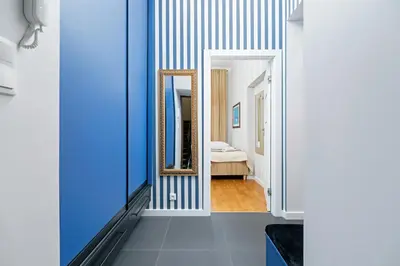 a hallway with blue and white walls and a mirror at Sweet Family Apartment Chodkiewicza Rondo Grzegórzeckie by Noclegi Renters in Kraków