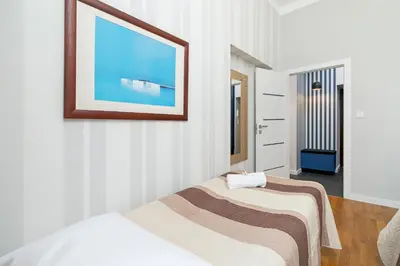 two beds in a room with a picture on the wall at Sweet Family Apartment Chodkiewicza Rondo Grzegórzeckie by Noclegi Renters in Kraków