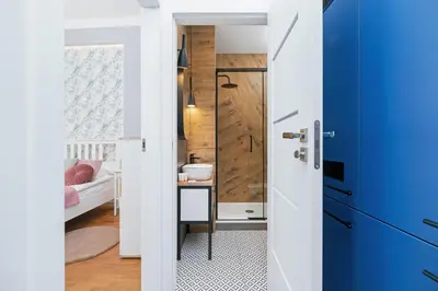 a small bathroom with a blue door and a desk at Sweet Family Apartment Chodkiewicza Rondo Grzegórzeckie by Noclegi Renters in Kraków