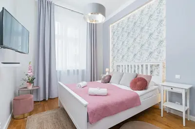 a bedroom with a white bed with a pink blanket at Sweet Family Apartment Chodkiewicza Rondo Grzegórzeckie by Noclegi Renters in Kraków