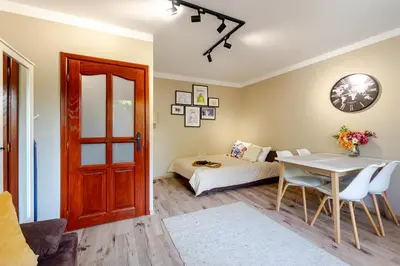 a room with a table and a bed and a door at Studio, Kraków - Czyżyny in Kraków