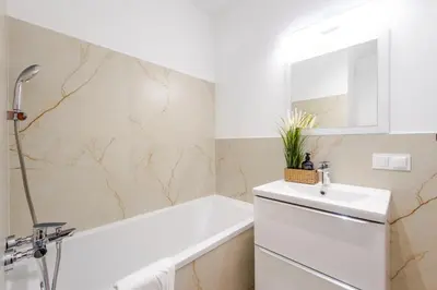 a bathroom with a white tub and a sink at Studio, Kraków - Czyżyny in Kraków