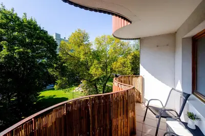 a balcony with two chairs and a view of trees at Studio, Kraków - Czyżyny in Kraków
