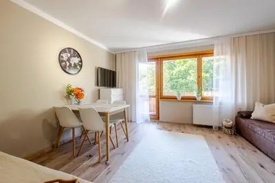 a living room with a table and chairs and a couch at Studio, Kraków - Czyżyny in Kraków