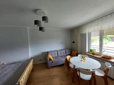 a bedroom with a bed and a table and a couch at Dom przy lesie in Zawadka