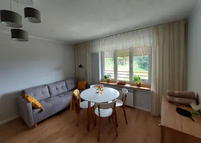 a living room with a couch and a table at Dom przy lesie in Zawadka