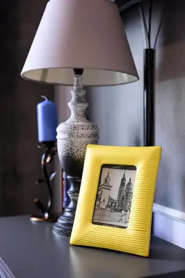 a yellow picture frame on a table next to a lamp at Native Apartments Studencka 25 in Kraków