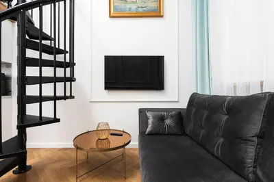 a living room with a couch and a tv at City of the Kings-Old Town Pastel Apartment in Kraków