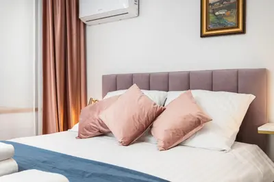 a bed with pink and white pillows on it at City of the Kings-Old Town Pastel Apartment in Kraków
