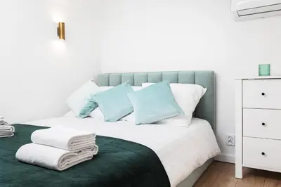 a bedroom with a bed with blue and white pillows at City of the Kings-Old Town Pastel Apartment in Kraków