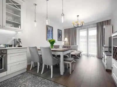a kitchen and dining room with a table and chairs at Wislane Tarasy by Tyzenhauz in Kraków