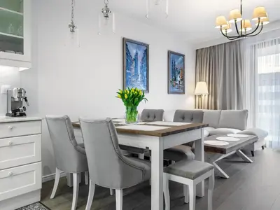 a kitchen and dining room with a table and chairs at Wislane Tarasy by Tyzenhauz in Kraków