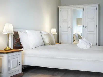 a white bedroom with a large bed with white pillows at Wislane Tarasy by Tyzenhauz in Kraków