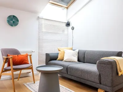 a living room with a couch and a chair at Tyzenhauz Apartments Piwna Street in Kraków
