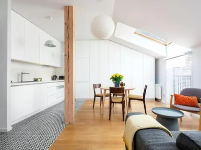 a kitchen and living room with a table and chairs at Tyzenhauz Apartments Piwna Street in Kraków