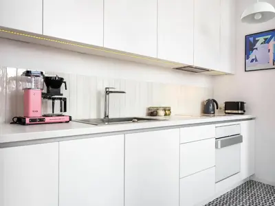 a kitchen with white cabinets and a sink at Tyzenhauz Apartments Piwna Street in Kraków