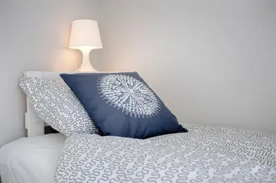 a blue pillow sitting on a bed with a lamp at Tyzenhauz Apartments Piwna Street in Kraków