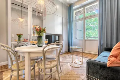 a dining room and living room with a table and chairs at Tyzenhauz Apartments Comfort in Kraków