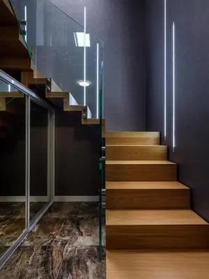a staircase in a building with wooden floors and glass railing at Tyzenhauz Apartments Comfort in Kraków
