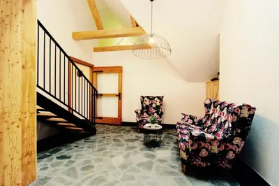 a living room with two chairs and a staircase at KOŃSKA GÓRKA Agroturystyka in Rabka