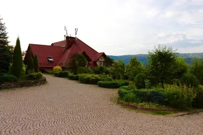 a house with a red roof and a gravel driveway at KOŃSKA GÓRKA Agroturystyka in Rabka
