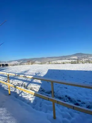 a snow covered field with a fence in the foreground at KOŃSKA GÓRKA Agroturystyka in Rabka