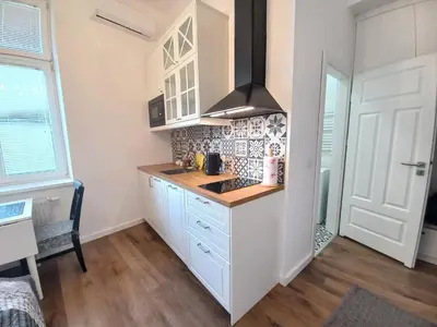 a kitchen with white cabinets and a stove at Krakowska Old Town Apartments - 16b in Kraków