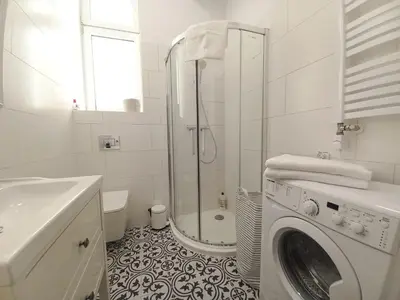a white bathroom with a washing machine in it at Krakowska Old Town Apartments - 16b in Kraków